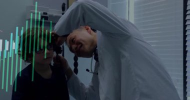 Erkek doktor çocuk üzerine eğiliyor, kulağı otoskopla inceliyor sağlık teknisyeninde yüzen ikonlarla birlikte. Tıbbi, sağlık, teşhis, profesyonel, klinik, pediatrik, danışma