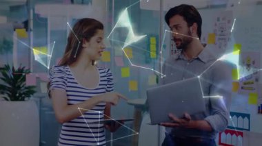 Modern ofis alanında, yüzen dijital dünya ağını gösteren cihazları tutan iki meslektaşım var. İşbirliği, yenilik, teknoloji, çalışma alanı, bağlantı, beyin fırtınası, profesyonel