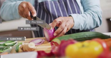 Sosyal medya bildirimleri patlarken kıdemli bir kadın kırmızı soğanı bıçakla dilimliyor. Yemek pişirme, aşçılık, yemek hazırlama, ev mutfağı, moda tarzı, modern, canlı