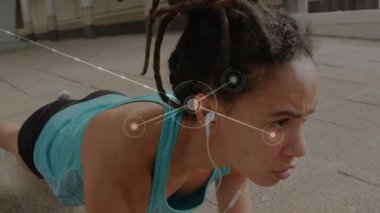 Yürüme yolu üzerinde egzersiz yapan, kulaklık takan, fitness ağı grafikleri olan bir kadın. Spor, sağlık, açık hava, teknoloji, kentsel, aktif, sağlık