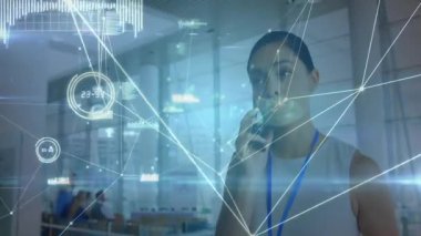 Şirket ofisinde akıllı telefon tutan bir kadın holografik ağ hatlarını ve veri simgelerini izliyor. Teknoloji, yenilik, iletişim, dijital, ağ, profesyonel, fütüristik