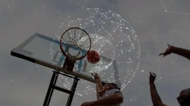 Basketbol, metal halka ve ağ boyunca hareket ediyor, bulutlu gökyüzünde dijital ağ örtüsünü gösteriyor. Spor, eğlence, teknoloji, yenilik, açık hava, dinamik, kentsel