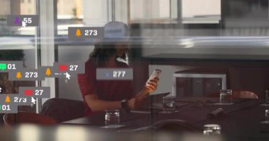 Tablet tutan kadın, toplantı odasında oturuyor, yüzen sosyal medya uyarı simgeleri gösteriyor. Teknoloji, profesyonel, minimalist, iş, iletişim, ağ, modern