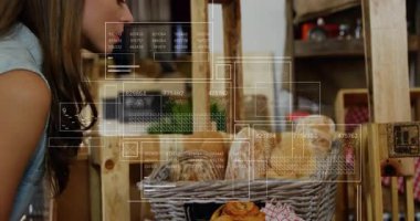 Hasır sepeti tezgahın üzerine doğru eğilen bir kadın fırın satışlarını izleyen veri panellerini gösteriyor. Sanatçı, köylü, modern, perakende, iç mekan, merak, analiz