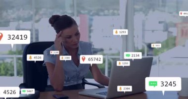 İş kadını masa başında yazı yazıyor, bildirim simgeleri dizüstü bilgisayar ve akıllı telefon üzerinde yüzüyor. Teknoloji, dijital, modern, profesyonel, çalışma alanı, kentsel, üretkenlik