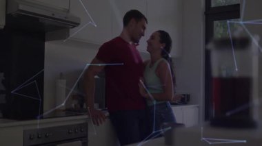 Kadın ve erkek mutfaktaki ocakta sevgi dolu anları paylaşıyor, akıllı ev ağlarını birleştiriyorlar. Romantik, samimiyet, teknoloji, modern, bağlantı, yaşam tarzı, iç mekan