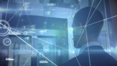Takım elbiseli bir adam ayakta durup cam duvarı seyrediyor. Teknoloji ağı hatlarını ve bar çizelgelerini gösteriyor. Fütüristik, teknoloji, ağ, arayüz, veri, şirket, yenilik
