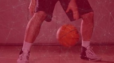 Erkek atlet turuncu basketbol topunu kırmızı zemine sürerek spor teknolojisi ağı örtüşmesini gösteriyor. Sporcu, spor, yarışma, fitness, hareket, enerji, teknoloji