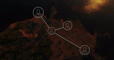 Kayalık kıyı şeridi üzerinde yüzen dijital ağ şeması ve gün batımını yansıtan altın deniz suları. Hava, kıyı, yansıtıcı, soyut, modern, bağlantı, günbatımı