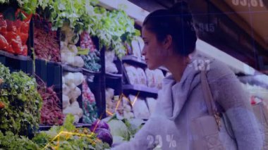 Perakende piyasasında yapraklı yeşilliklere uzanan bir kadın yüzen veri grafikleri ve numaraları gösteriyor. Taze ürün, market alışverişi, perakende satış ortamı, piyasa analitiği, sağlıklı yaşam tarzı, organik sebzeler, tüketici davranışı