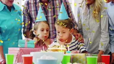Aile alkışı ve doğum günü mumlarını söndüren çocuklar. Canlandırılmış altın konfetileri havada süzülüyor. Kutlama, çok nesilli, neşeli, neşeli, sıcak, yaşam tarzı, mutluluk