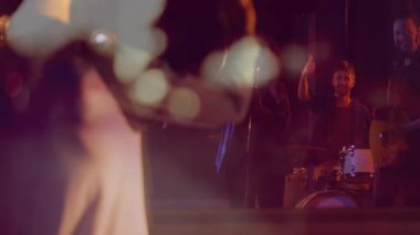 Sakallı müzisyen müzik sahnesinde kollarını kavuşturup animasyon ses ikonu ve ses dalgalarını gösteriyor. Performans, müzik, eğlence, konser, sahne, gece hayatı, ses