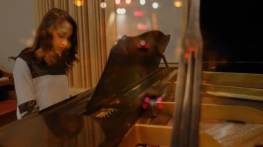 Müzik stüdyosunda piyano çalan, animasyon notaları ve parlak bokeh çalan bir kadın. Müzik, yaratıcılık, zarafet, akustik, performans, ambians, modern