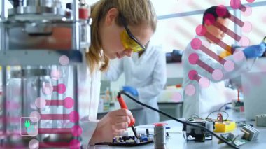 Dişi araştırmacı, yüzen DNA iplikçikleri ve geri dönüşüm simgelerinin altındaki laboratuarda lehimleme devresi kullanıyor. Bilim, yenilik, teknoloji, sürdürülebilirlik, işbirliği, deney, kesinlik