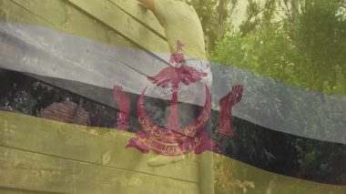 Fitness eğitimi sırasında tahta engelli duvara tırmanan adam yarı şeffaf bayrak kaplaması gösteriyor. Macera, dayanıklılık, engebeli, açık hava, meydan okuma, kararlılık, spor