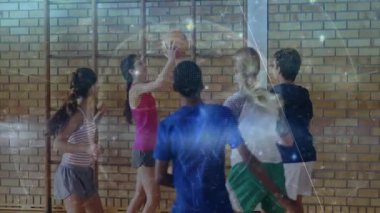 Spor salonunda basketbol antrenmanı yapan genç takım arkadaşları eğitim teknisyenleri için üst üste bindirme gösteriyorlar. Sporcular, takım çalışması, antrenman, fitness, dinamizm, spor, gençlik