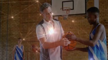 Erkek koç, basketbolu beden eğitimi dersindeki genç oyuncuya paslıyor. Sağlık temalı, parlak çizgili. Spor, antrenman, fitness, takım çalışması, atletik, motivasyon, eğlence