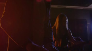 Loş bir konser sahnesinde sahne alan klavye müzisyeni renkli spot ışıklarının üzerinde animasyon notaları gösteriyor. Konser, performans, eğlence, sahne, ışıklandırma, ses, ritim