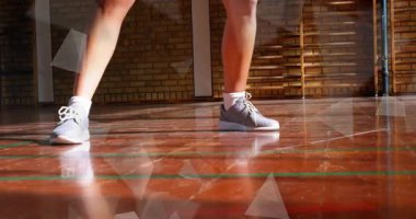 Spor salonunda, spor ayakkabıları ve saha çizgilerinin etrafında gezinen hareketli fitness verileriyle duran bir bayan sporcu. Atletik, spor, antrenman, spor, spor salonu, giysi, hareket