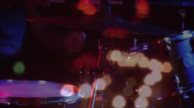 Davul zili karanlık bir performans içinde, titreyen bokeh ışıkları düz tasarımla parlıyor. Müzisyen, performans, aydınlatma, sahne, ritim, enerji, hareket