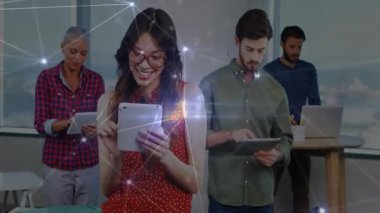Teknoloji ekibi tabletleri tutuyor ve ofiste dizüstü bilgisayar kullanıyor, parlayan düğümler ve bağlantılar sergiliyor. Dijital, bağlantı, takım çalışması, modern, yenilik, işbirliği, canlı