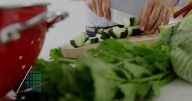 Mutfakta salatalık dilimleyen kadın sağlık analizleri için dijital bar çizelgeleri gösteriyor. Sağlıklı, aşçı, minimalist, dijital, taze, besleyici, modern