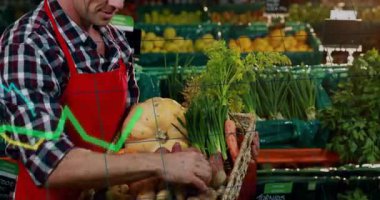 Marketin üretim bölümünde patatesi inceleyen yetişkin bir erkek tezgahtar çizgi grafiklerini gösteriyor. Taze ürün, perakende, kırsal, sağlıklı, pazar, kalite, tarım