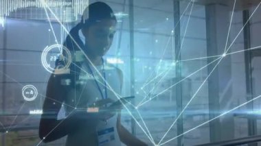 Atriyumda elinde akıllı telefon tutan bir kadın teknoloji ağı grafikleri ve bar çizelgeleri gösteriyor. Gelecekçi, yenilikçi, bağlantı, kurumsal, modern, veri görselleştirme, profesyonel