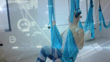 Yoga pratisyeni, ağ hatları ve veri tablolarıyla fitness stüdyosunda hava yogası yapıyor. Esneklik, denge, güç, dijital, modern, sağlık, disiplin
