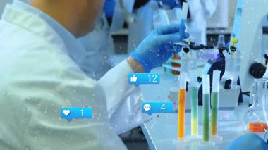 Olgun bir araştırmacı bilim laboratuarında yüzen sosyal medya simgeleriyle dizüstü bilgisayarda verileri inceliyor. Bilim, yenilik, işbirliği, araştırma, teknoloji, laboratuvar, analitik