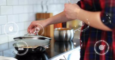 Ev mutfağında paslanmaz çelik kapağı kaldıran adam teknoloji büyüme grafikleri ve bilgi simgeleri gösteriyor. Aşçılık, mutfak, teknoloji, yenilik, aşçılık, modern yaşam tarzı