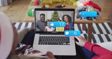 Noel Baba şapkası takan izleyiciler dizüstü bilgisayarlarında yüzen simgelerle teknolojiyi sergiliyorlar. Şenlikli, rahat, teknoloji, kutlama, tatil, bağlantı, sıcaklık