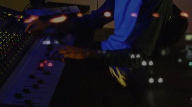 Masada çalışan kulaklık takan sakallı bir adam. Monitörde hareketli teknik grafikler var. Teknoloji, odak, ambians, modern, yaratıcı, üretkenlik, ışıklandırma