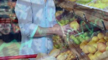 Ahşap üretim kutuları arasında sarı meyve tutan orta yaşlı bir adam, perakende veri çizelgeleri sergiliyor. Taze ürün, perakende analizi, sağlıklı beslenme, market alışverişi, pazar eğilimleri, diyet, tüketici davranışı