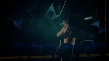 Kadın sporcu karanlık sahnede ipe tırmanıyor, fitness holografik küresi ve ışık yollarını birleştiriyor. Sporcu, yenilik, fütürist, güç, kararlılık, teknoloji, güç