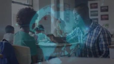 Öğretmen diz çöküp, eğitim sınıfında holografik küre örtüşmesi gösteren beş öğrenci masası veriyor. Öğrenme, akıl hocalığı, gençlik, teknoloji, yenilik, işbirliği, ilham