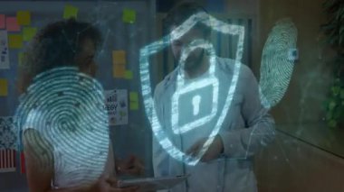 Ofisteki tableti inceleyen iki meslektaşım hologram parmak izi taramaları ve kalkan ikonu hazırlıyorlar. Teknoloji, işbirliği, yenilik, modern, kurumsal, güvenlik, iletişim