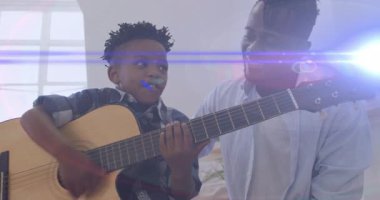 Babam pencere merceğinin yanındaki gitar eğitimi seansında animasyon akor diyagramlarını gösteriyordu. Aile, akıl hocalığı, müzik, eğitim, sıcaklık, ilham, sükunet