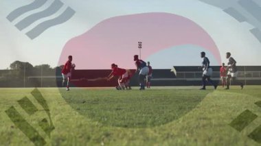 Kırmızı rugby topu taşıyıcısı reaksiyona girdi. Düştü, topu aldı ve sayı yapmak için koştu. Atletizm, rekabet, dayanıklılık, eylem, takım çalışması, sportmenlik, canlı