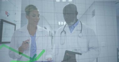 Sağlık verilerini analiz eden doktorların panoya tıklama tabletine işaret ettiği yeşil çizgi grafiği. Tıp uzmanları, işbirliği, veri analizi, sağlık izleme, sağlık teknolojisi, klinik takım çalışması, bilgi toplama