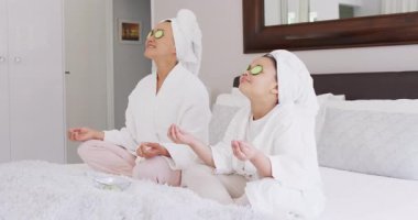 Mutlu Asyalı anne ve kızının salatalık maskesi takıp dinlendiği bir video. Aile, annelik, ilişkiler ve birlikte kaliteli zaman geçirme konsepti dijital olarak oluşturulmuş video.