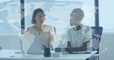 Dünya haritasında iş yerini gösteren bir kadın bilgisayardan iş arkadaşı olarak el kol hareketi yaparak kağıt alışverişinde bulunuyor. İşbirliği, profesyonellik, çeşitlilik, yenilik, modern, iletişim, takım çalışması