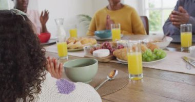 Afro-Amerikan ailelerin, kız çocuklarının ve büyükbabalarının yemek masasında dua ettikleri videolar. Aile, aile hayatı ve birliktelik kavramı dijital olarak oluşturulmuş video.