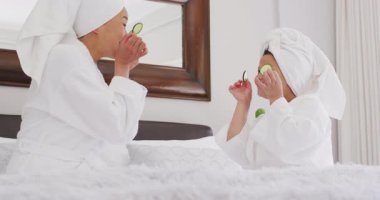 Mutlu Asyalı anne ve kızının salatalık maskesi takıp eğlendiği bir video. Aile, annelik, ilişkiler ve birlikte kaliteli zaman geçirme konsepti dijital olarak oluşturulmuş video.