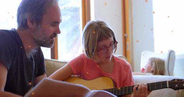 Baba sayfaları çeviriyor ve altın kaplamalı müzik dersinde gitar akorları çalan kızına rehberlik ediyor. Aile, akıl hocalığı, akustik, eğitici, samimi, duygusal, sanatsal