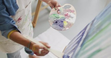 Stüdyoda resim yapan kadın ressamın orta bölümünün videosu. Sanat, el sanatları, yaratıcılık ve yaratılış süreci kavramı.