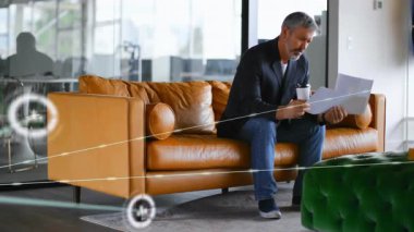 Danışman kanepeye yerleşiyor, gazete okuyor ve iş görüşleri için canlı yayın yapıyor. Profesyonel, modern, dijital, ağ, iş, şirket, gündelik