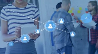 Yapışkan notları paylaşan kadın, ikonları genişleterek tablet tıklayarak teknoloji ağını görselleştiriyor. Dijital bağlantı, takım çalışması, yenilik, işbirliği, modern ofis, teknoloji, beyin fırtınası