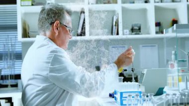 Laboratuvar kıdemli bilim adamı test tüpüne ulaşıyor ve dijital parçacıkların arasında analiz için örnek topluyor. Araştırma, deney, yenilik, kesinlik, teknoloji, analiz, bilimsel