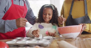 Afrika kökenli mutlu bir Amerikalı torunun büyükannesi ve büyükbabasıyla mutfakta pasta yaptığı video. Aile, aile hayatı ve birliktelik kavramı dijital olarak oluşturulmuş video.